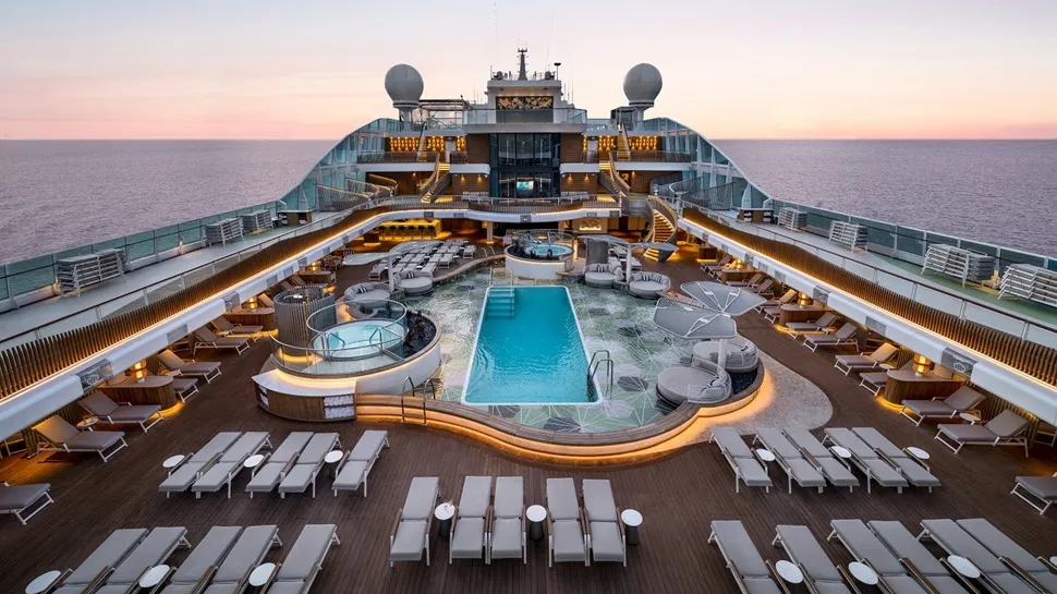 Guests relaxing on the open-air pool deck under blue skies